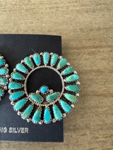 Turquoise earrings on a black card with 'Nugget Silver' text, against a wooden background.