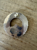 Silver ring with 'ZB' stamp on a wooden surface