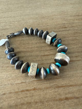 Bracelet with silver and turquoise beads on a wooden surface